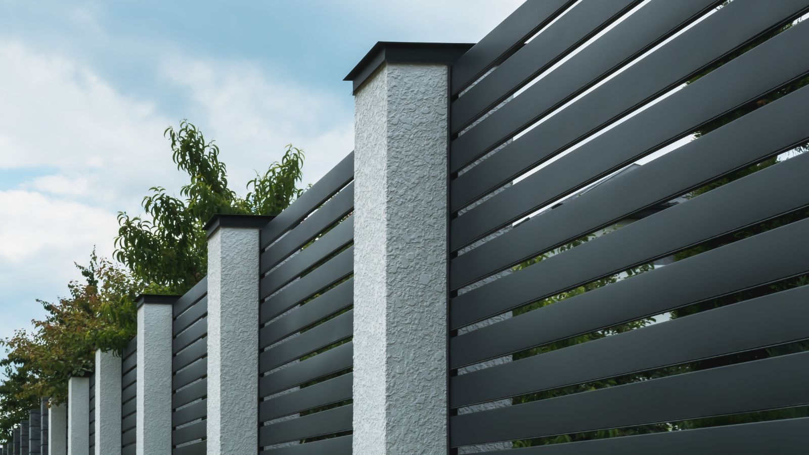 A close-up shot of a composition of dark-colored aluminum fencing, all situated in a well lit area outdoors