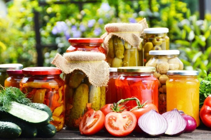 A close-up shot of a composition of various jarred crops, showcasing the best vegetables to preserve