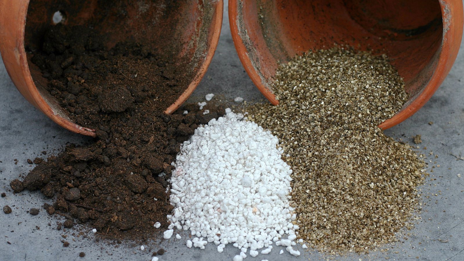 A shot of several pots that are tipped over showcasing various soil amendments situated in a well lit area outdoors