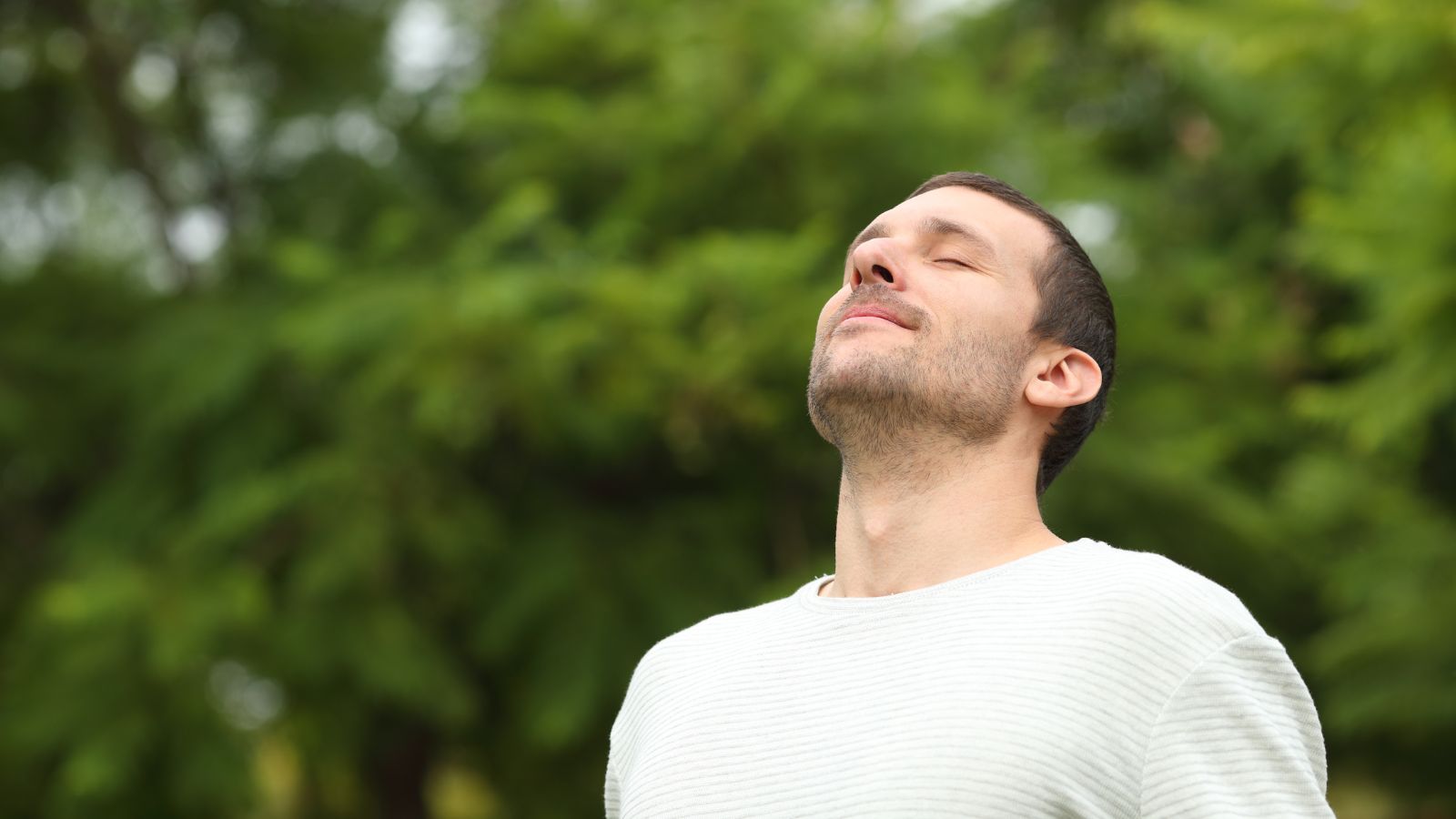 A close-up shot of a person breathing in fresh air in a tree forest area outdors
