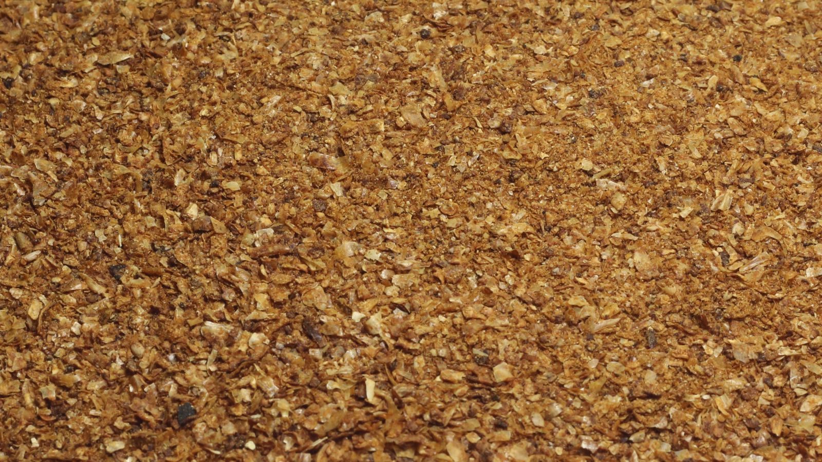 A dried pile of milled corn appearing to have an orange brown color with pieces placed on top of each other