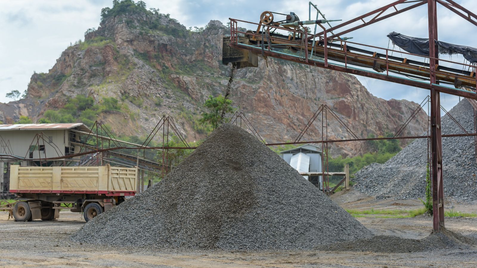 rock phosphate being processed at a mill, appearing to have a mechanism pouring the material on to the ground in a pile