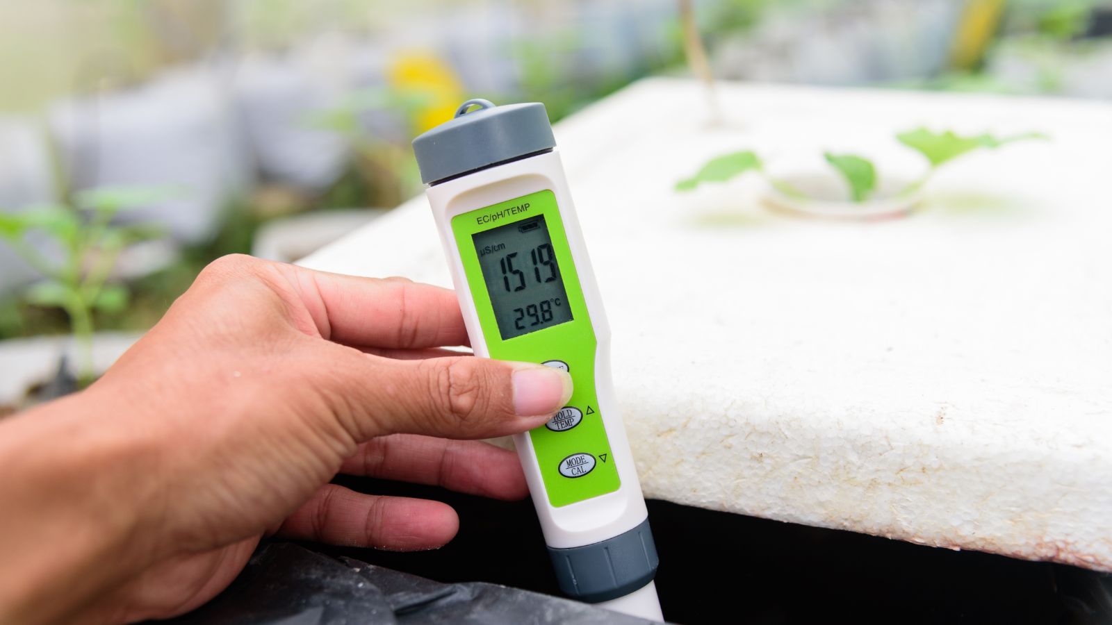 A close-up shot of a water tester in a soilless growing environment, showcasing the quality and ph levels