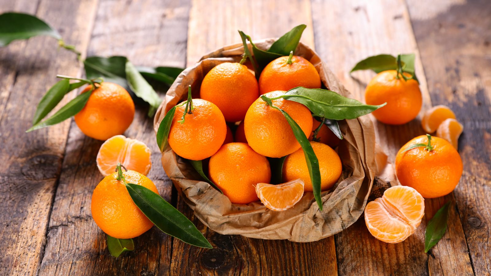A shot of a pile of freshly harvested orange fruits in a paper bag