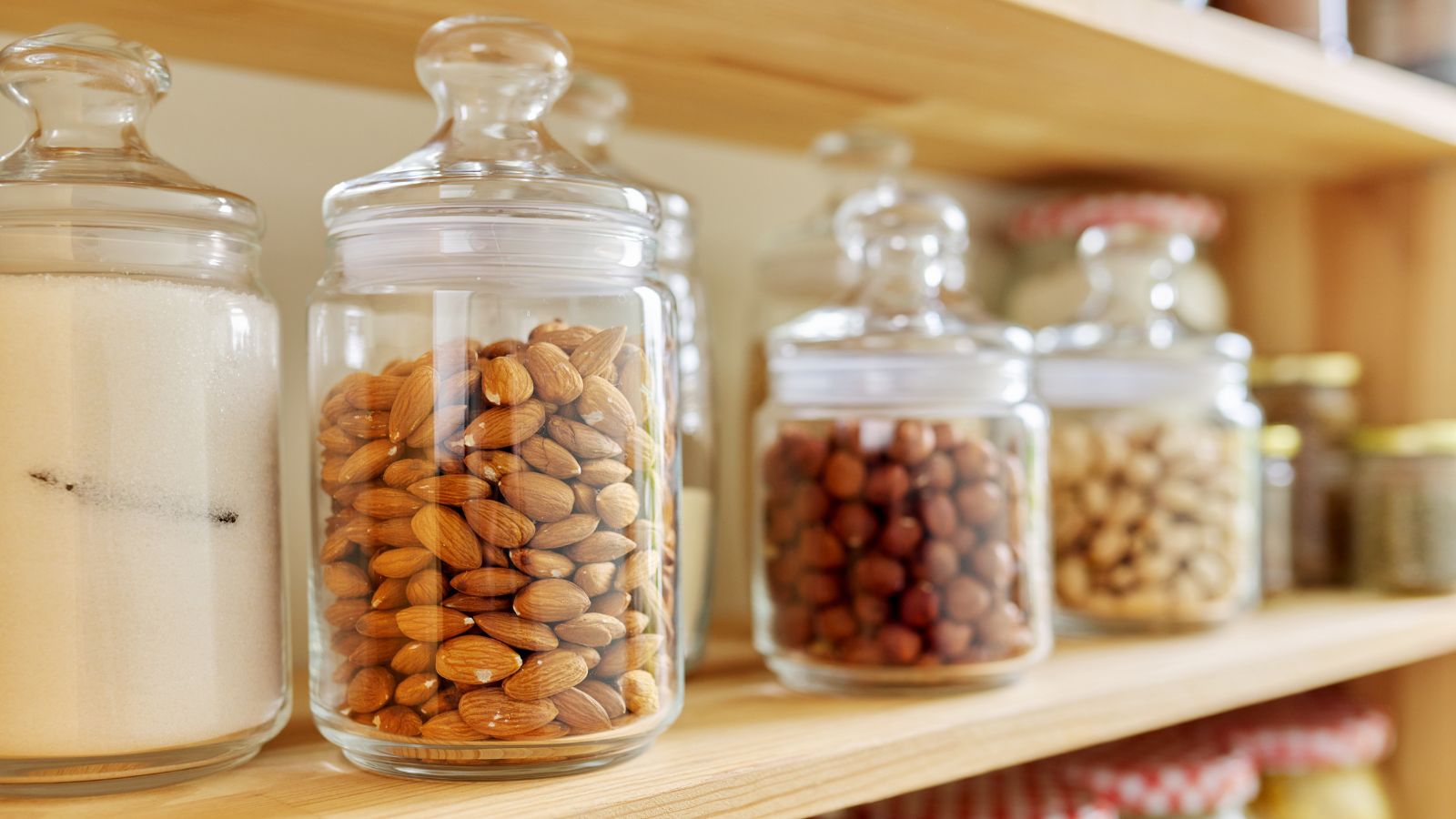 A shot of several jars of nuts placed on a kitchen pantry