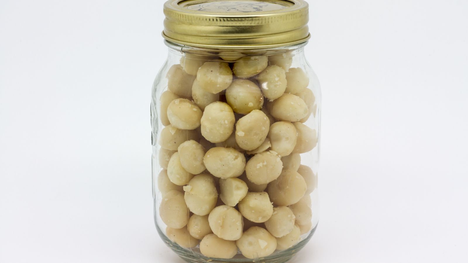 A shot of a glass jar filled with hard dry fruits in a well lit area