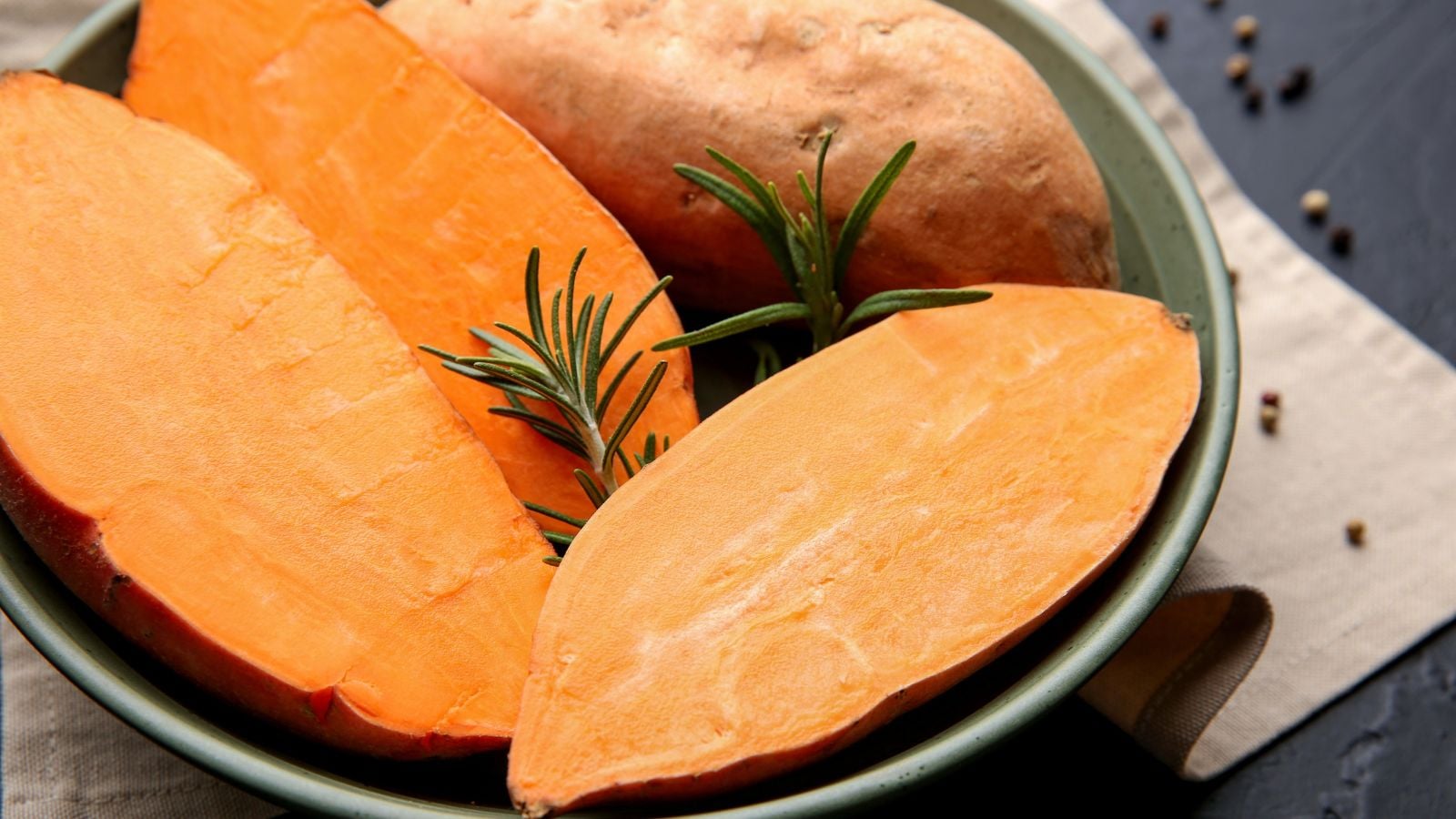 An overhead and close-up shot of several raw and uncooked crops called Bellevue, placed on a small bowl and featuring bright orange flesh and copper skin