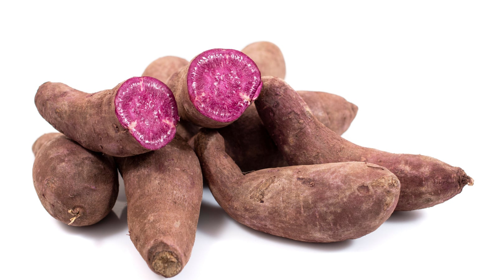 An isolated and close-up shot of a small pile of purplish-brown colored variety of crops called Stokes Purple®, showcasing its purple colored flesh