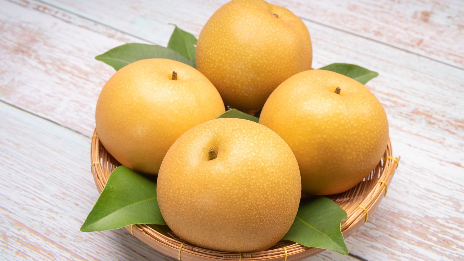 An overhead shot of freshly harvested fruits on a bamboo tray in a well lit area
