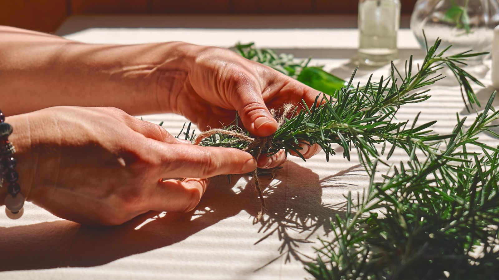 A shot of person in the process of tying freshly picked plants in a well lit area indoors
