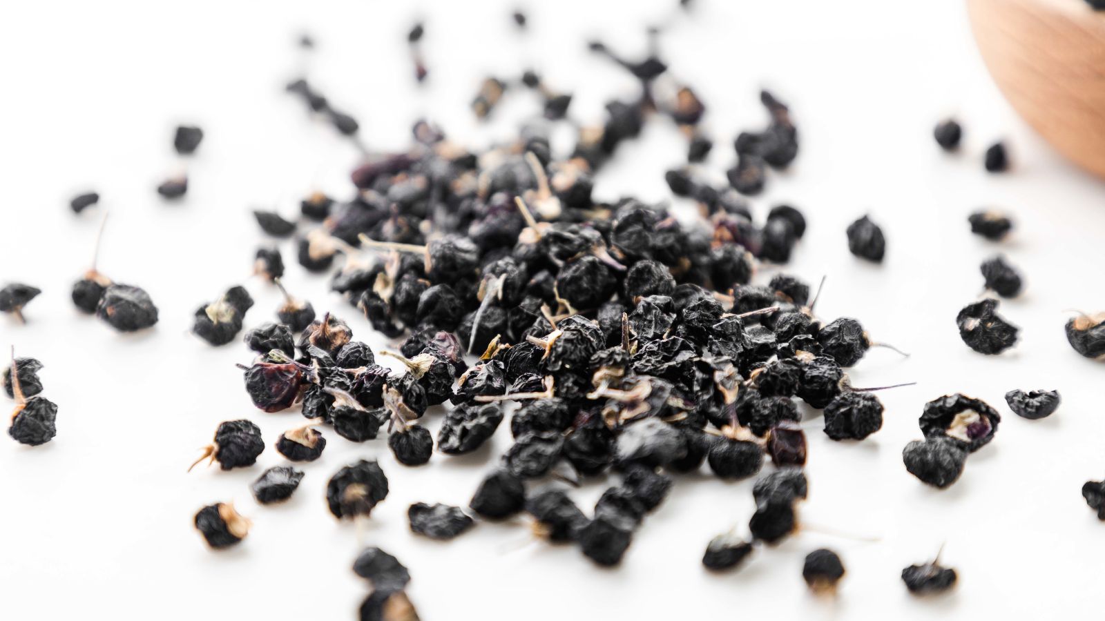 A shot of black seeds of a plant on a white surface