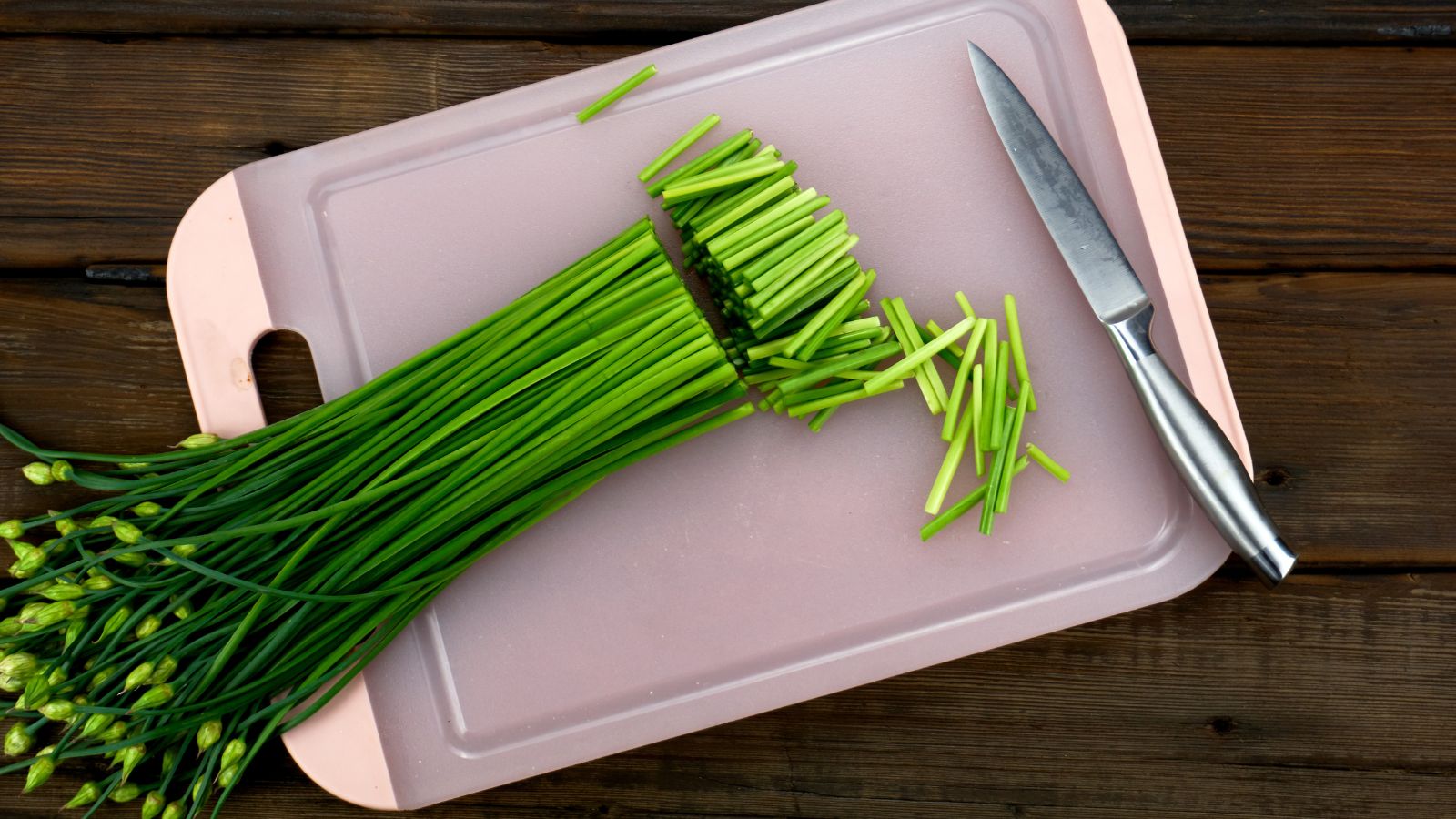 An overhead shot of a freshly harvesed crop being cut on a chopping board in a well lit area