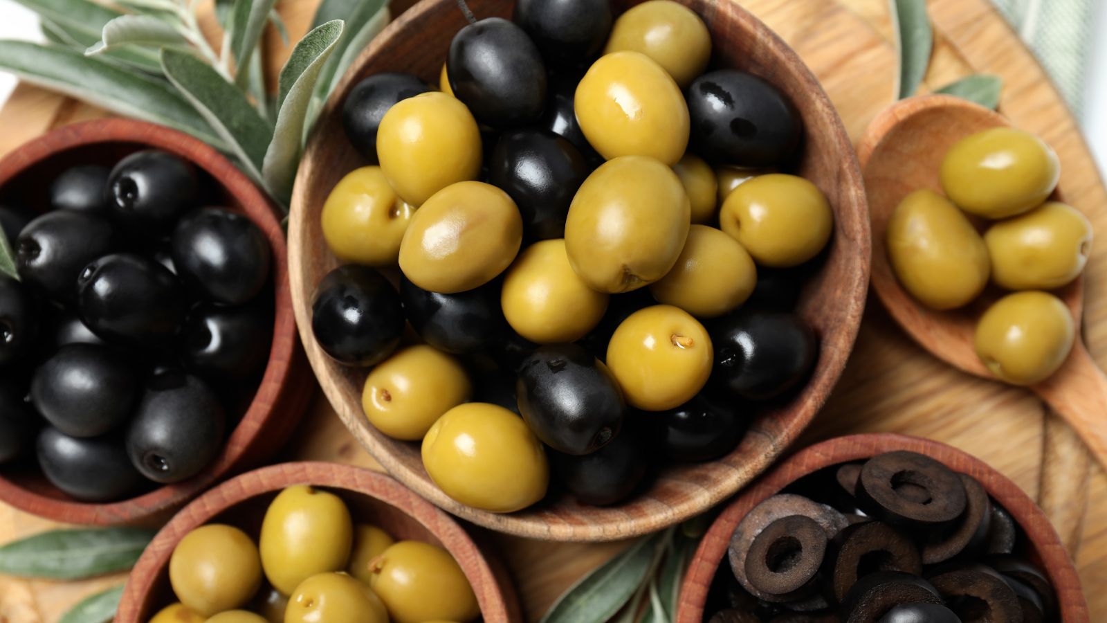 An overhead shot of fresh fruits placed on wooden bowls indoors