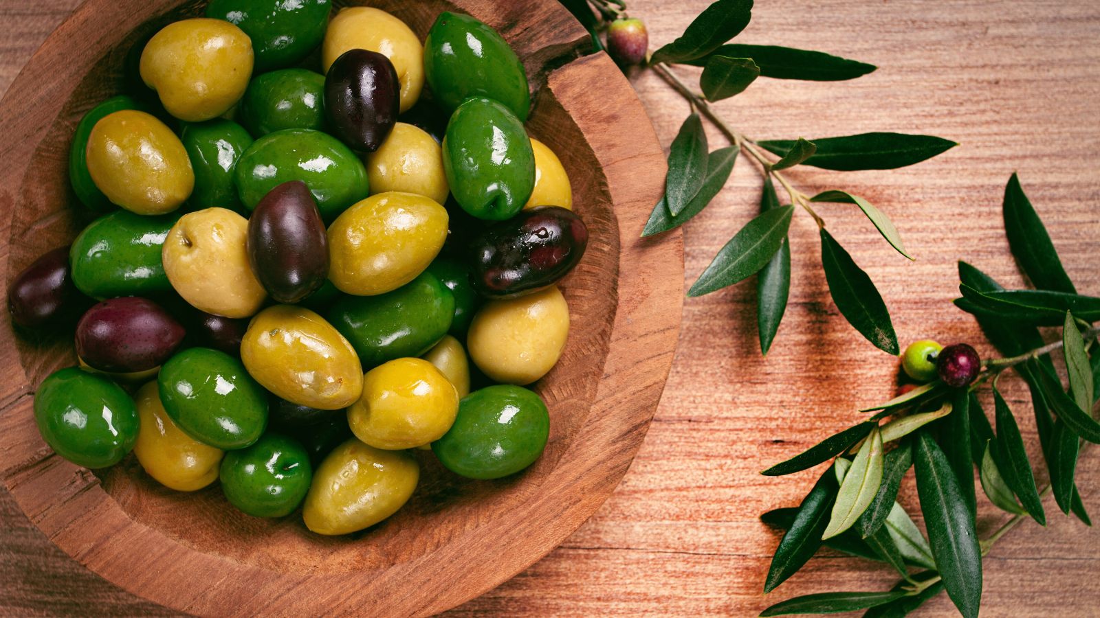 An overhead shot of several varieties of fruit placed in a bowl