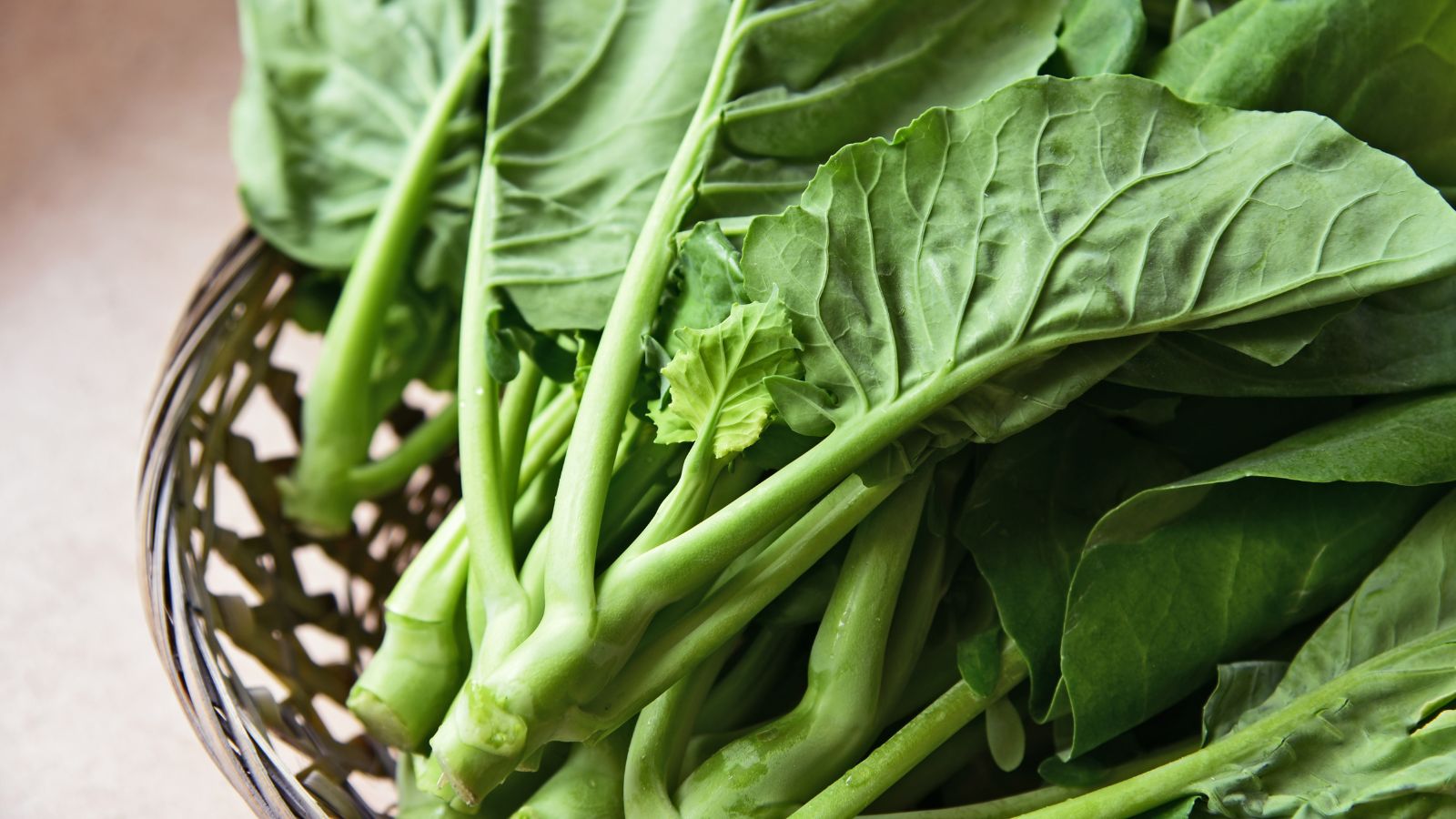 A shot of several fresh green crops on a woven tray