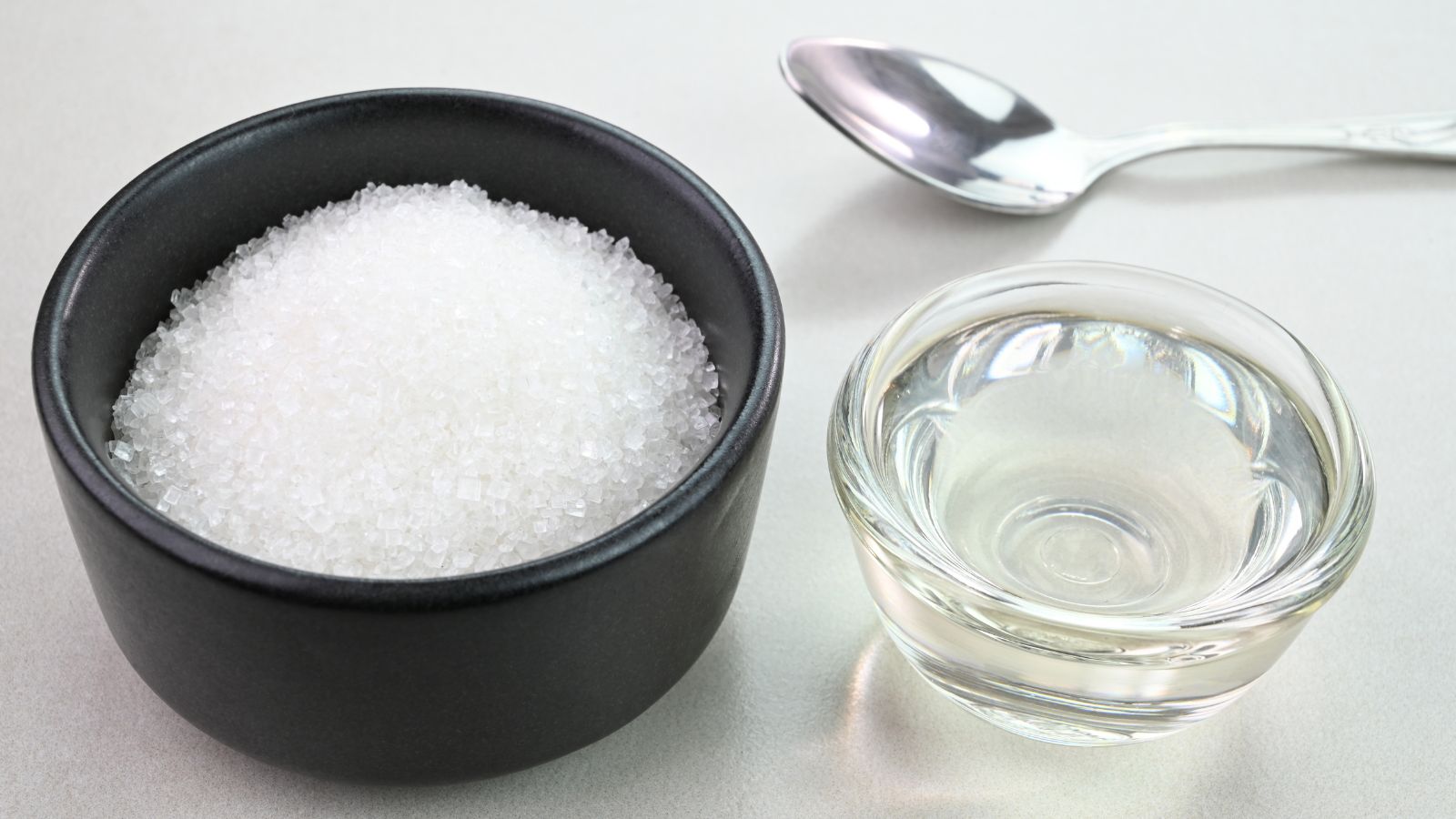 A close-up and overhead shot of several containers, containing sugar, and homemade nectar, all situated in a well lit area outdoors