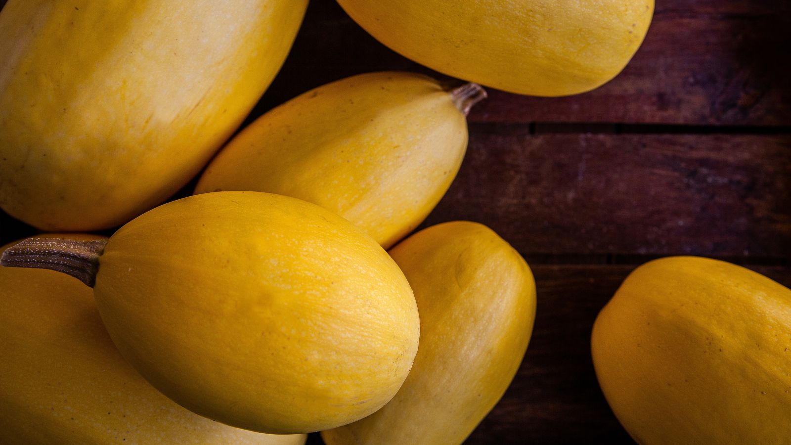 An overhead shot of ripe yellow fruits on a wooden surface in a well lit area