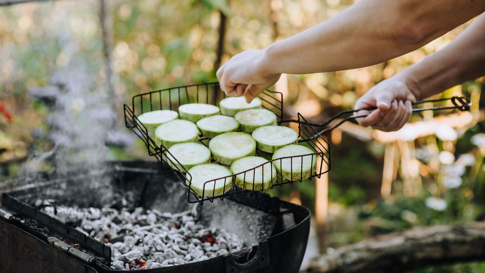 A person in the process of smoking slices of a gourd in a well lit area outdoors