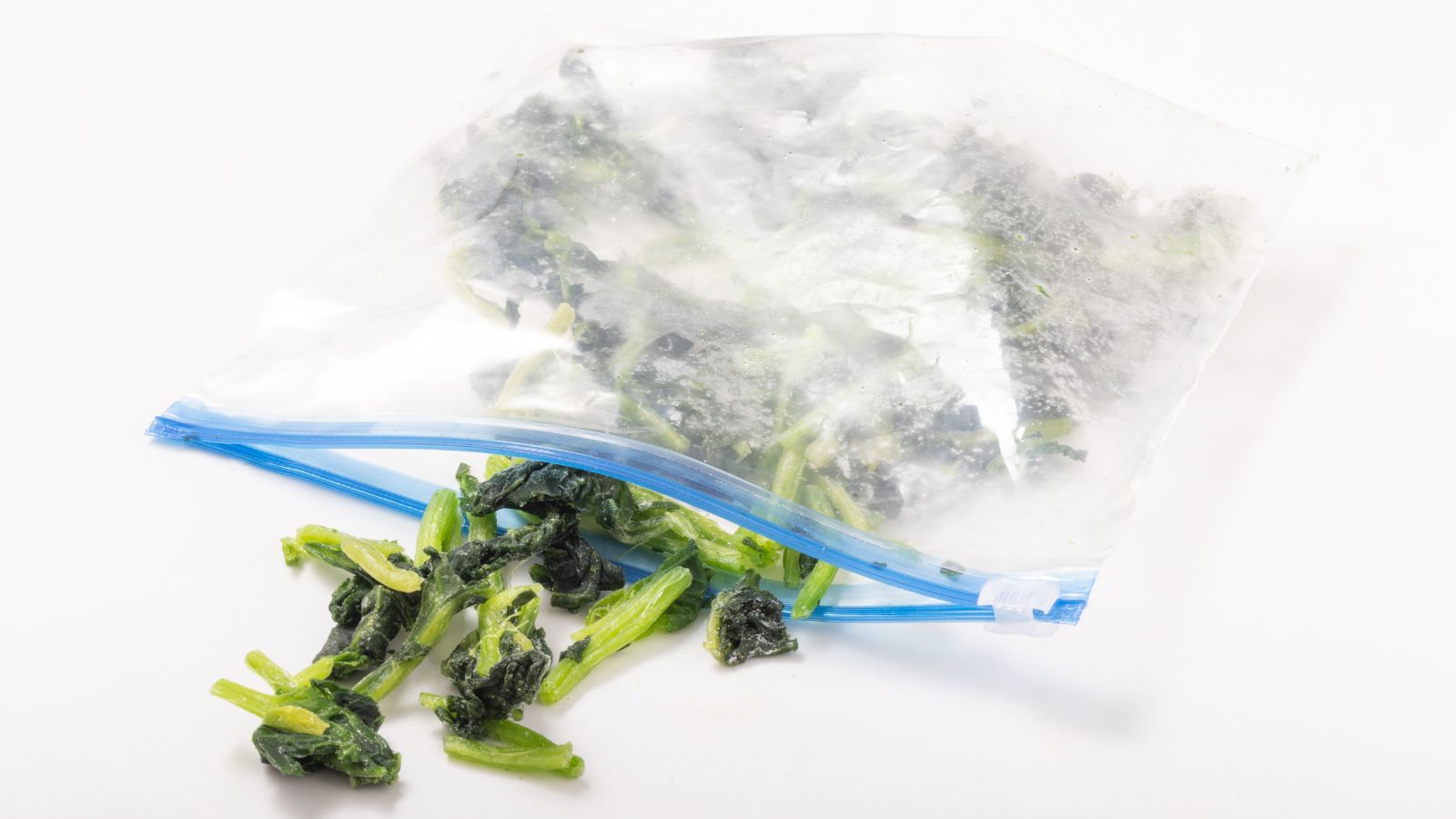 An isolated shot of frozen leaves in plastic bag, placed on a pure white surface