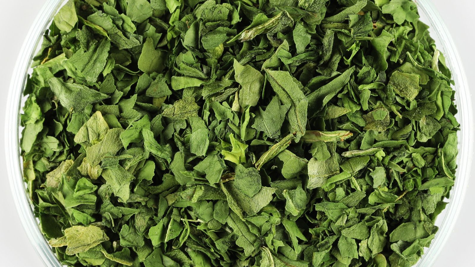 An overhead shot of dried leafy green crops, placed in a bowl under bright light